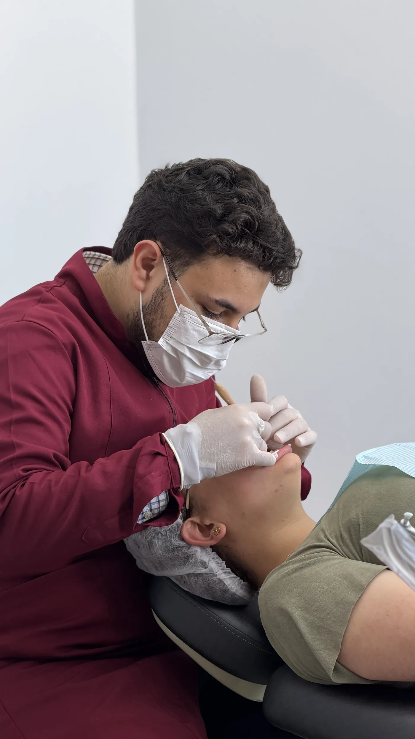 Dr. Alex E. Pedroso atendendo paciente na cadeira odontológica do consultório